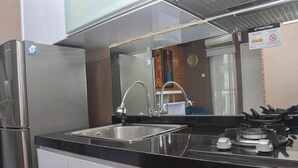 Una cocina moderna con un refrigerador de acero inoxidable, un fregadero y una estufa.