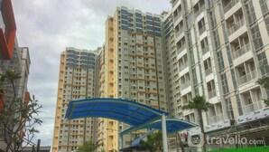 Un edificio residencial alto con varios balcones y una estructura de toldo azul en primer plano.
