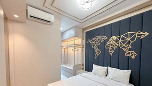 A modern hotel room with a large bed, a world map wall decoration, a wardrobe, and an air conditioning unit. - Great Choice And Fabulous 2Br At Benson Supermall Mansion Apartment (Surabaya)