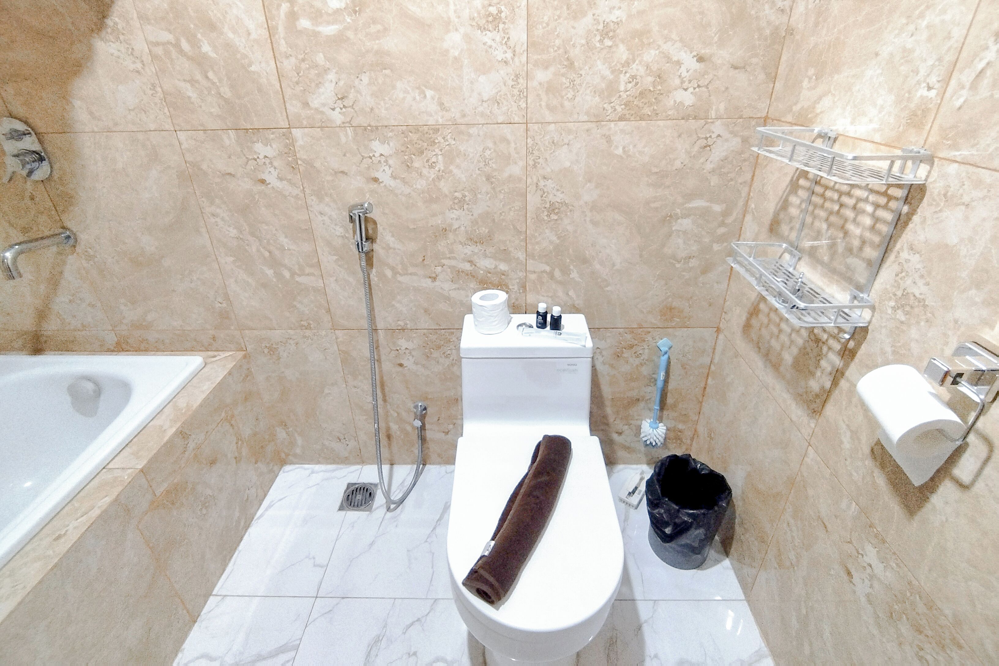 A bathroom with a toilet, a shower, a bathtub, and a towel rack.