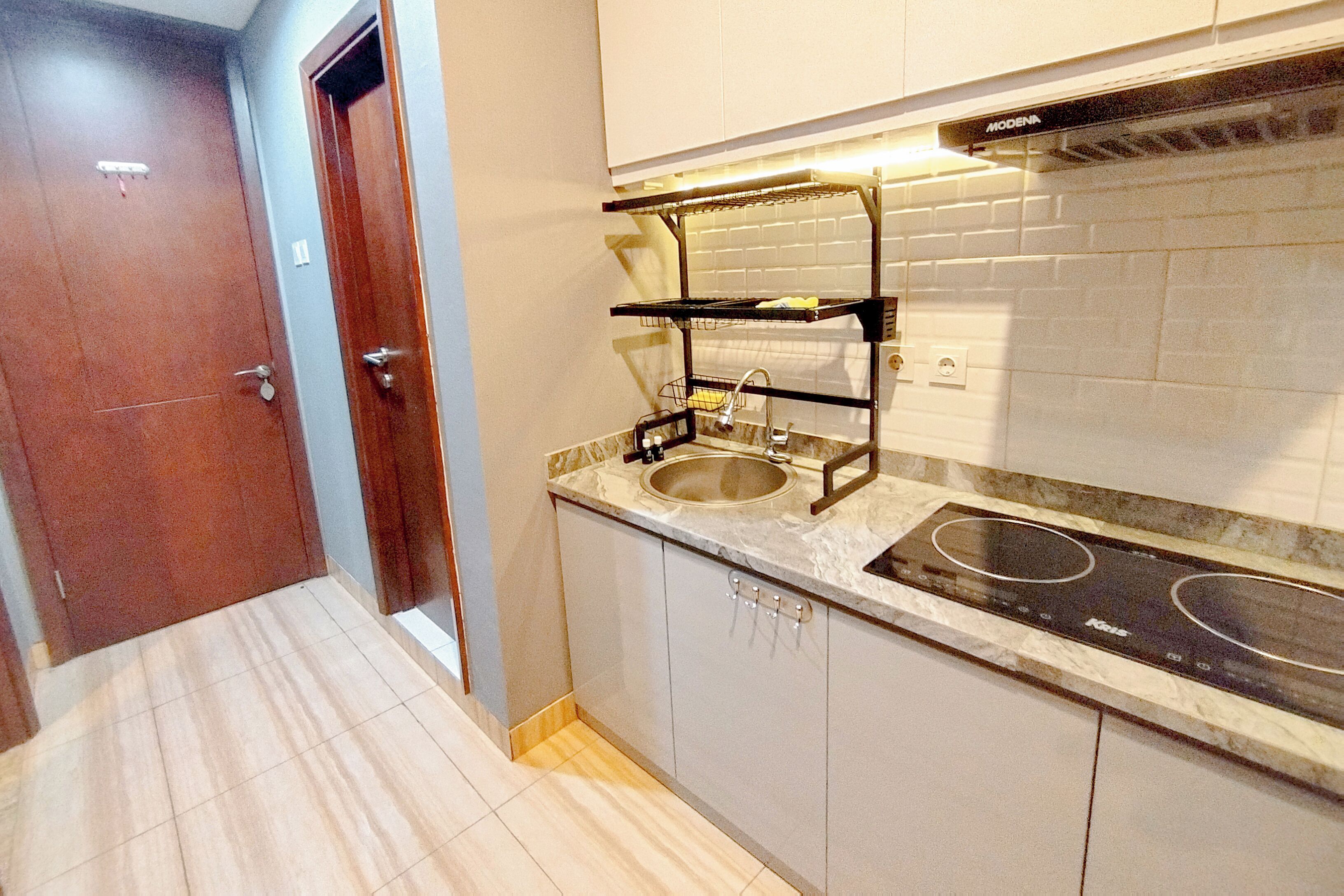 A kitchen with a sink, stove, and a metal rack above the sink.