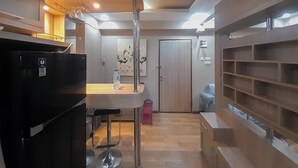 Een moderne keuken met een zwarte koelkast, een bargedeelte en een houten kast.