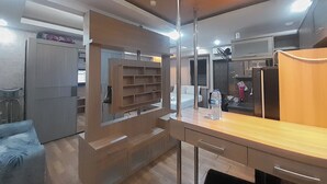 Een moderne keuken met inbouwplanken, een houten aanrechtblad en een koelkast.