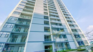 A tall, modern high-rise building with multiple balconies and large windows. - Cozy Studio Daan Mogot City Apartment (Jakarta)