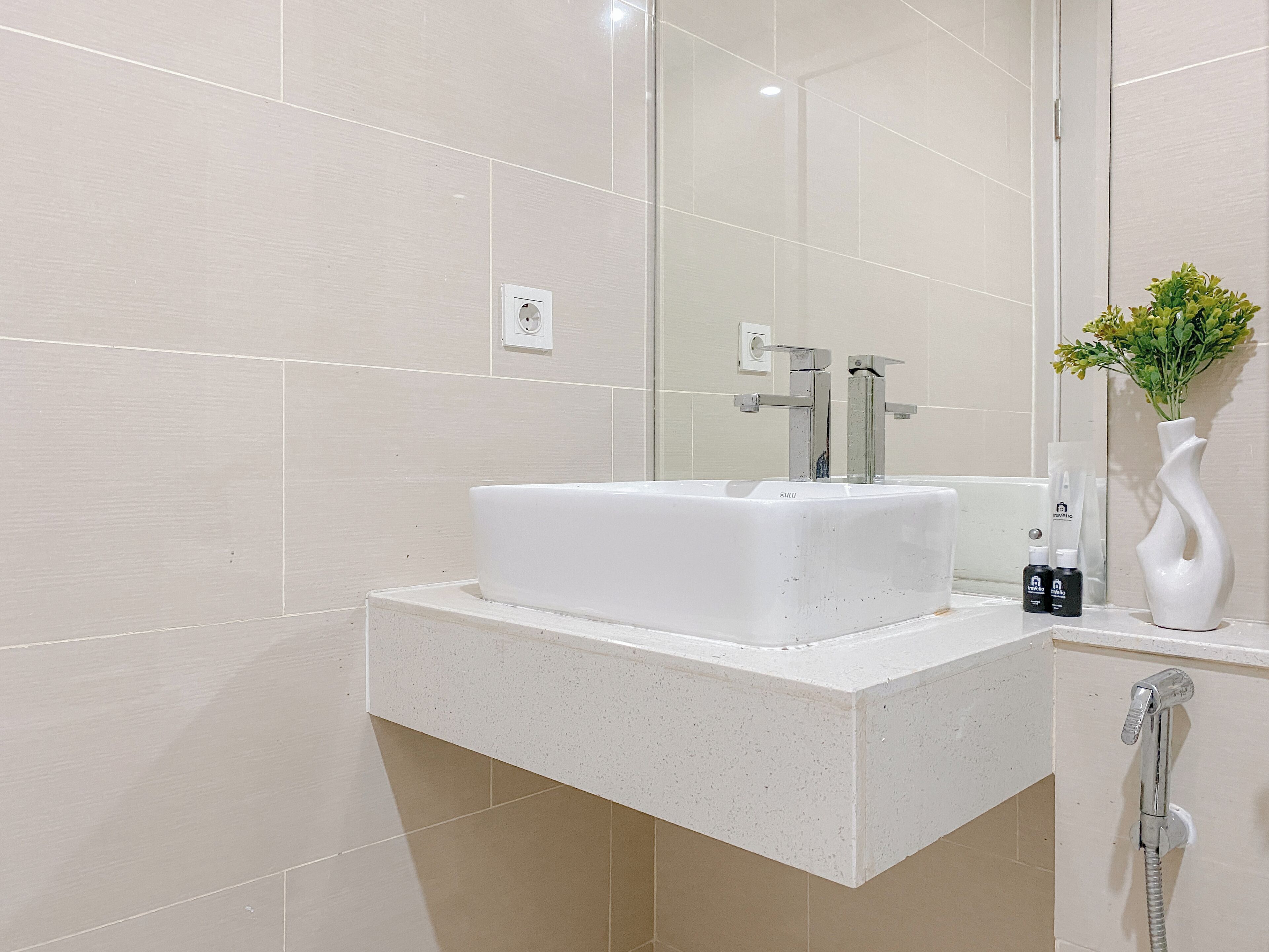 A bathroom with a white sink, a mirror, and a shower.