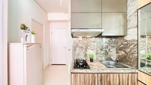 A compact kitchen with a built-in stove, a sink, and a modern backsplash. - Best Deal And Warm 2Br Apartment Green Pramuka City (Jakarta)