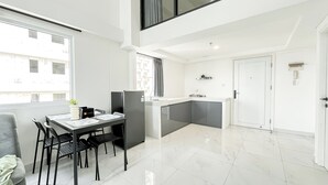 Un appartamento moderno con zona pranzo, cucina e balcone.