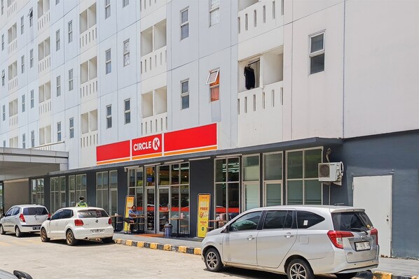 Un magasin Circle K, avec une façade moderne, de grandes fenêtres et un espace de stationnement bien visible où sont garées plusieurs voitures.