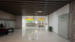 A clean, modern indoor space with a tiled floor, a visible exit sign, and a store named 'Tamel Mart' in the background. - Good Deal Stunning Studio (No Kitchen) At Taman Melati Surabaya Apartment (Surabaya)