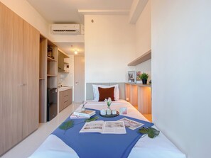 A bedroom with a bed, bedside table, and a wardrobe. - Warm Stay Studio At Tokyo Riverside Pik 2 Apartment (Teluknaga)