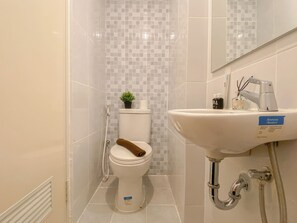 A bathroom with a toilet, a sink, and a shower. - Warm Stay Studio At Tokyo Riverside Pik 2 Apartment (Teluknaga)