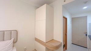 Une chambre à coucher avec un lit, une armoire et un banc en bois.