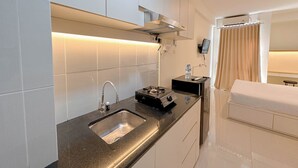 Une cuisine moderne dotée d’un évier en acier inoxydable, d’une cuisinière à gaz et d’un four encastré.