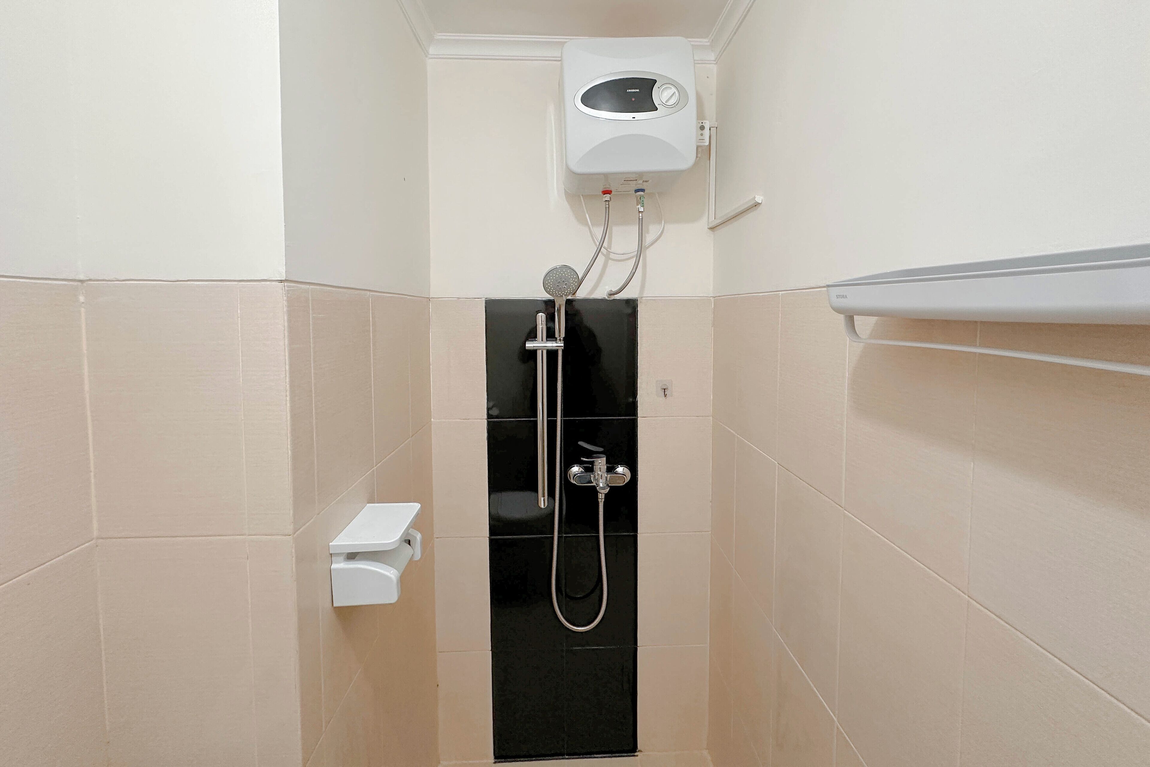 A small, enclosed shower area with a built-in heater, a handheld showerhead, and a wall-mounted toilet.