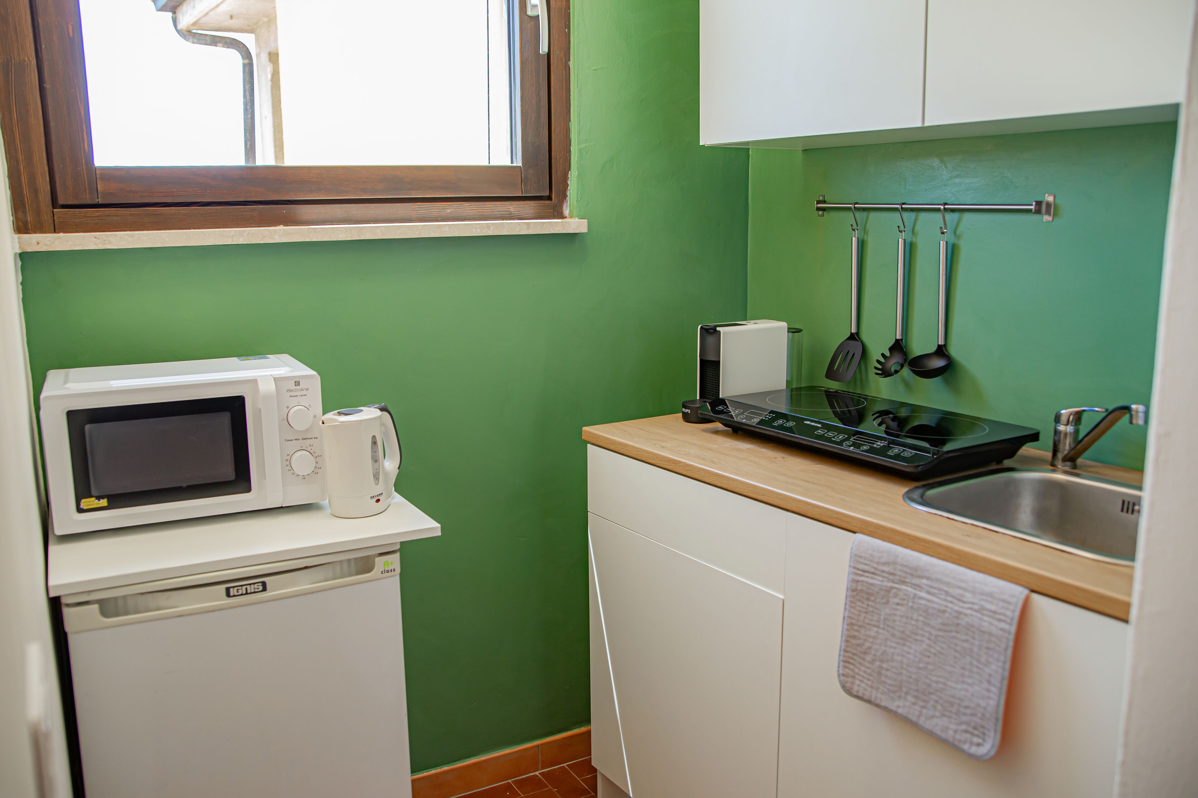 Cocina compacta con microondas, tostadora y fregadero.