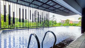 An outdoor swimming pool with metal railings and a covered area. - Modern Studio Apartment At Cordova Edupartment Semarang (Semarang)