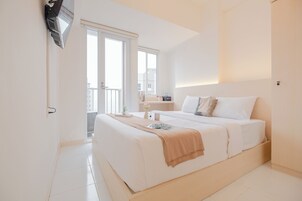 Habitación de hotel moderna con una cama grande, un balcón y vistas a la ciudad.
