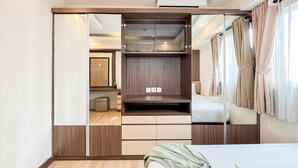 Une chambre à coucher avec une armoire, un lit et un miroir.