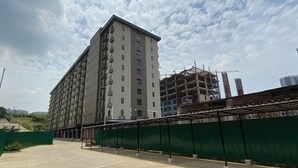 A multi-story building with balconies and a construction site nearby. - Best Deal And Homey Studio At Meikarta Apartment (Cikarang)