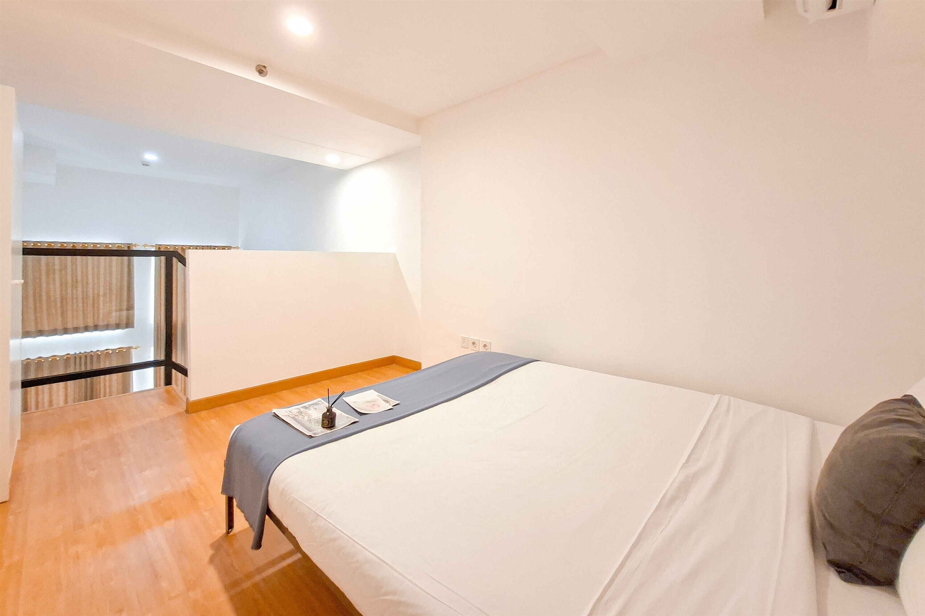 A bedroom with a bed, a bedside table, and a window.