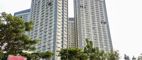 A high-rise building with multiple balconies and a sign indicating a show unit.