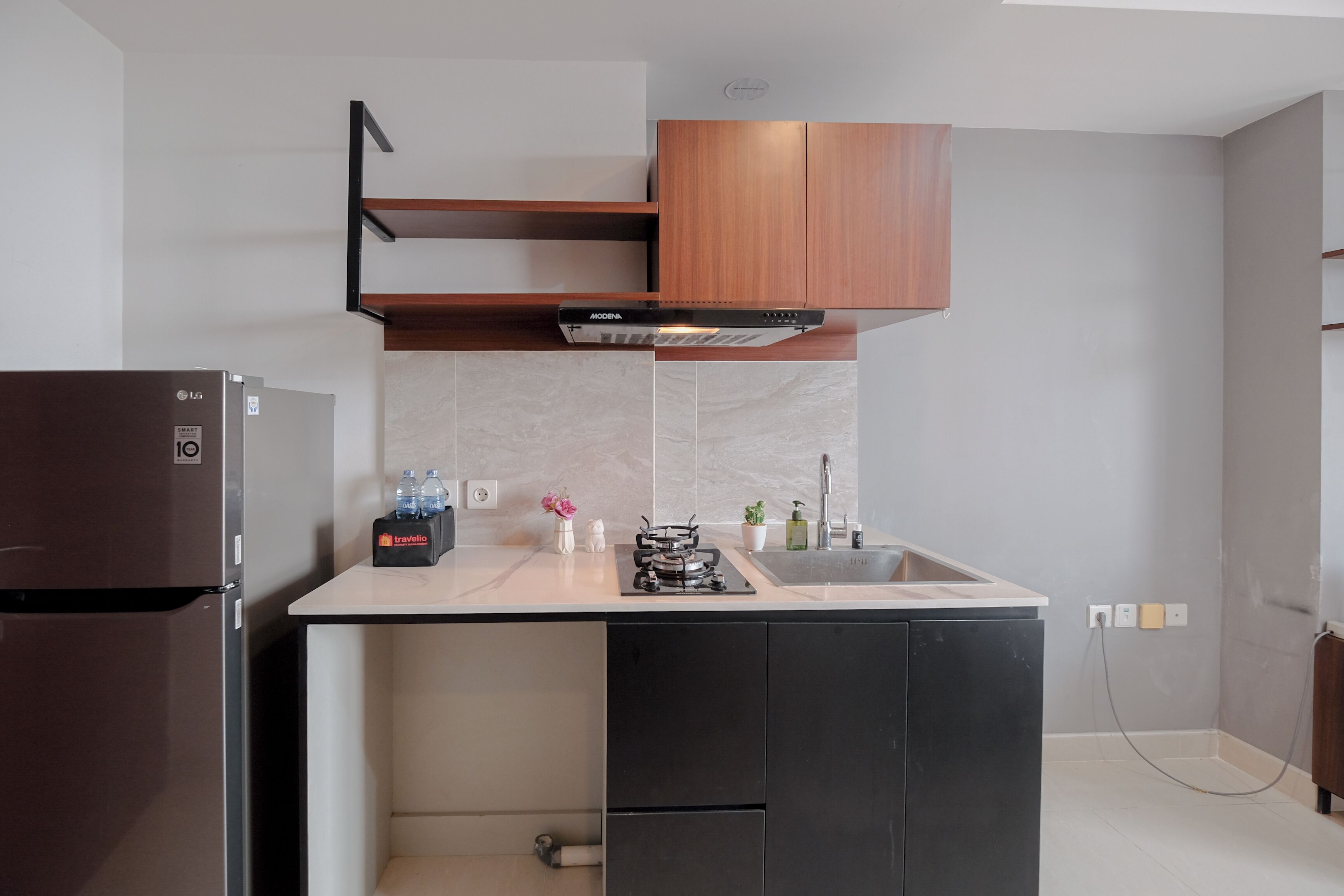 A compact kitchen with a built-in refrigerator, a gas stove, and wooden cabinets.