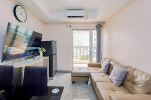 Een moderne woonkamer met een flatscreen televisie, een bank, een eethoek en een balkon met uitzicht.