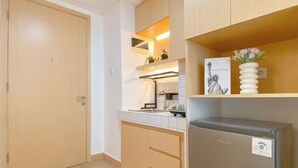 Eine kleine Küche mit Holzausstattung, einem Einbauofen und einem Kühlschrank.