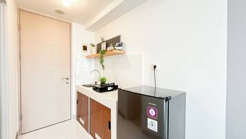Une cuisine moderne équipée d’un réfrigérateur encastré, d’un évier et d’un meuble en bois.