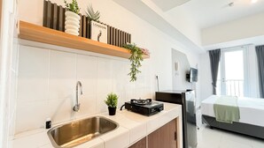 Una cocina moderna con un lavamanos de acero inoxidable, un horno empotrado y un pequeño electrodoméstico negro sobre la encimera.