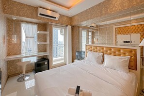 Habitación de hotel con una cama grande, tocador con espejo, ventana con cortinas y un minibar.
