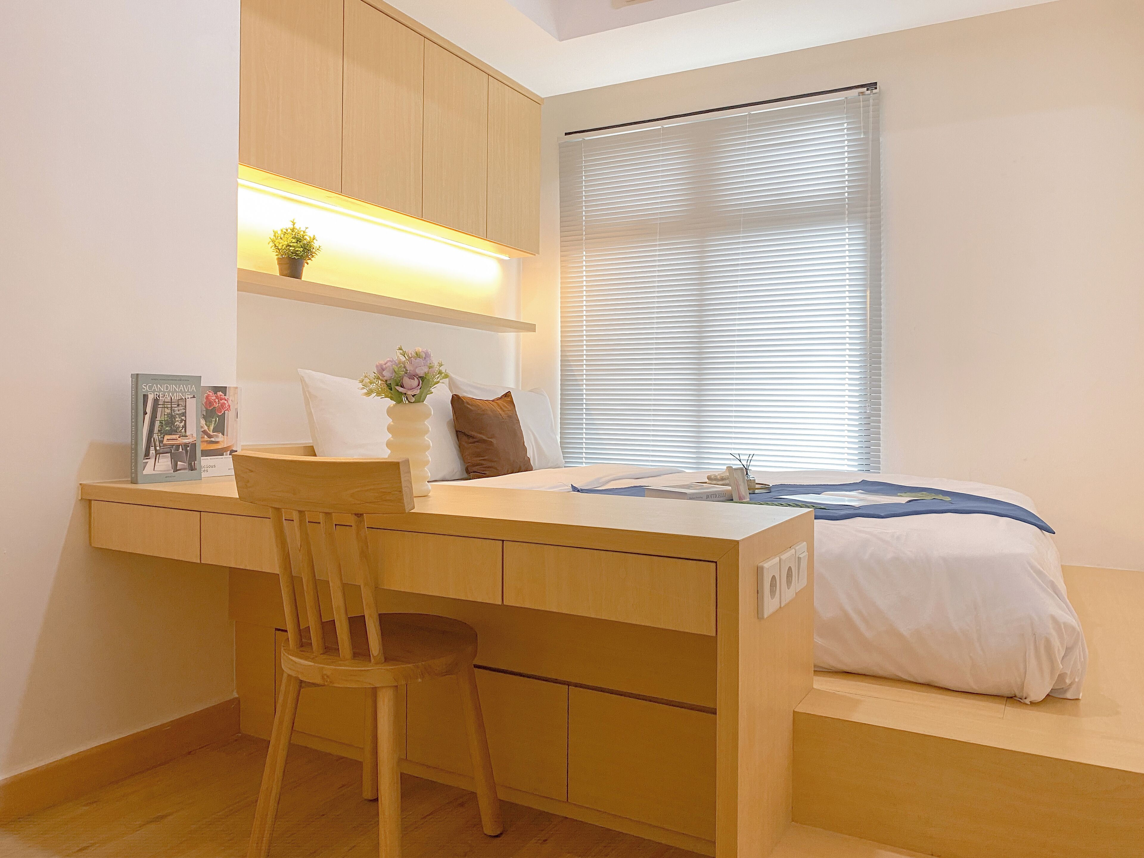 A bedroom with a desk, chair, bed, and a window with blinds.