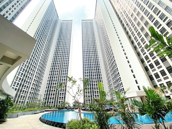 A high-rise building with a pool and lounge area.