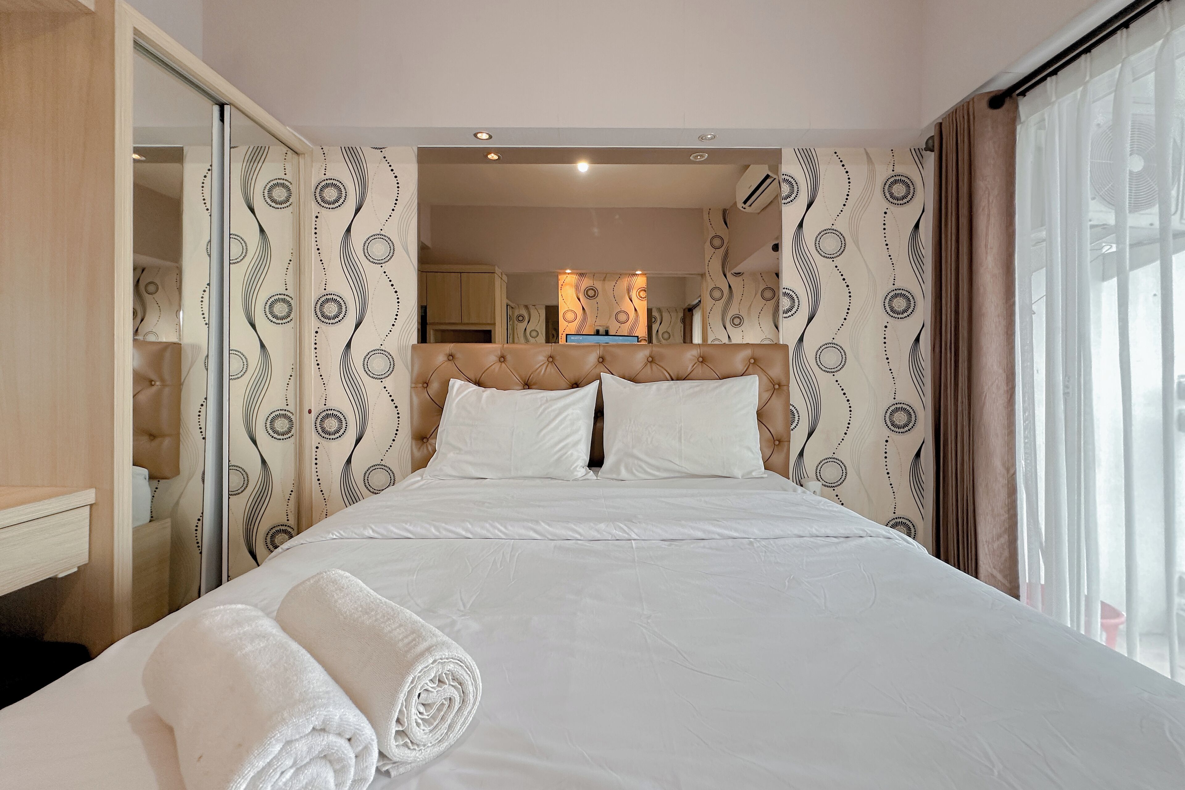 Une chambre d’hôtel avec un grand lit, une salle de bain avec une porte en verre et une vue sur la cuisine.