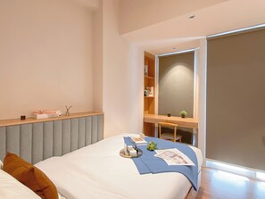 A modern bedroom with a bed, a desk, and a wardrobe. - Neat And Warm Studio At Tokyo Riverside Pik 2 Apartment (Teluknaga)