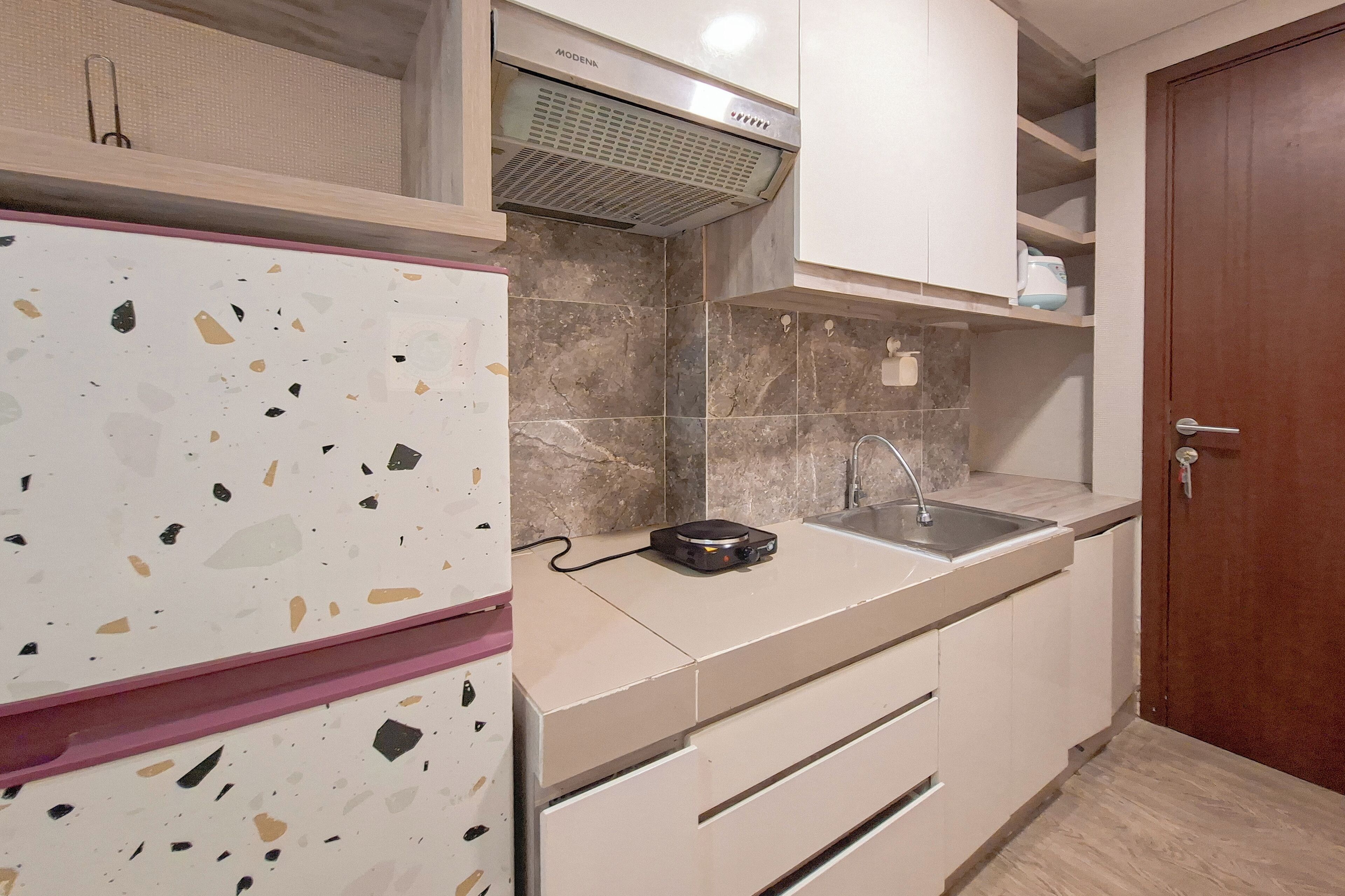 A kitchen with a white refrigerator, a built-in oven, a microwave, and a sink.