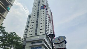 A tall, modern building with multiple floors and a prominent sign for Sahid Serpong. - Pleasant Studio Apartment Parkland Avenue (South Tangerang)