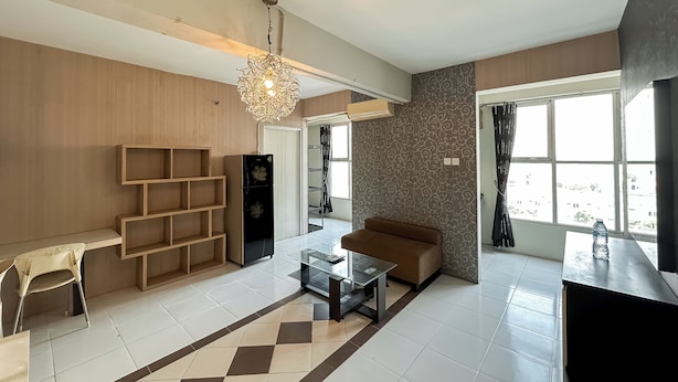 A modern living room with a sofa, coffee table, and shelves. - 3Br Combined Spacious At Dian Regency Apartment (Surabaya)