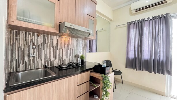 Una cocina moderna con armarios de madera, un lavamanos de acero inoxidable y una estufa integrada.