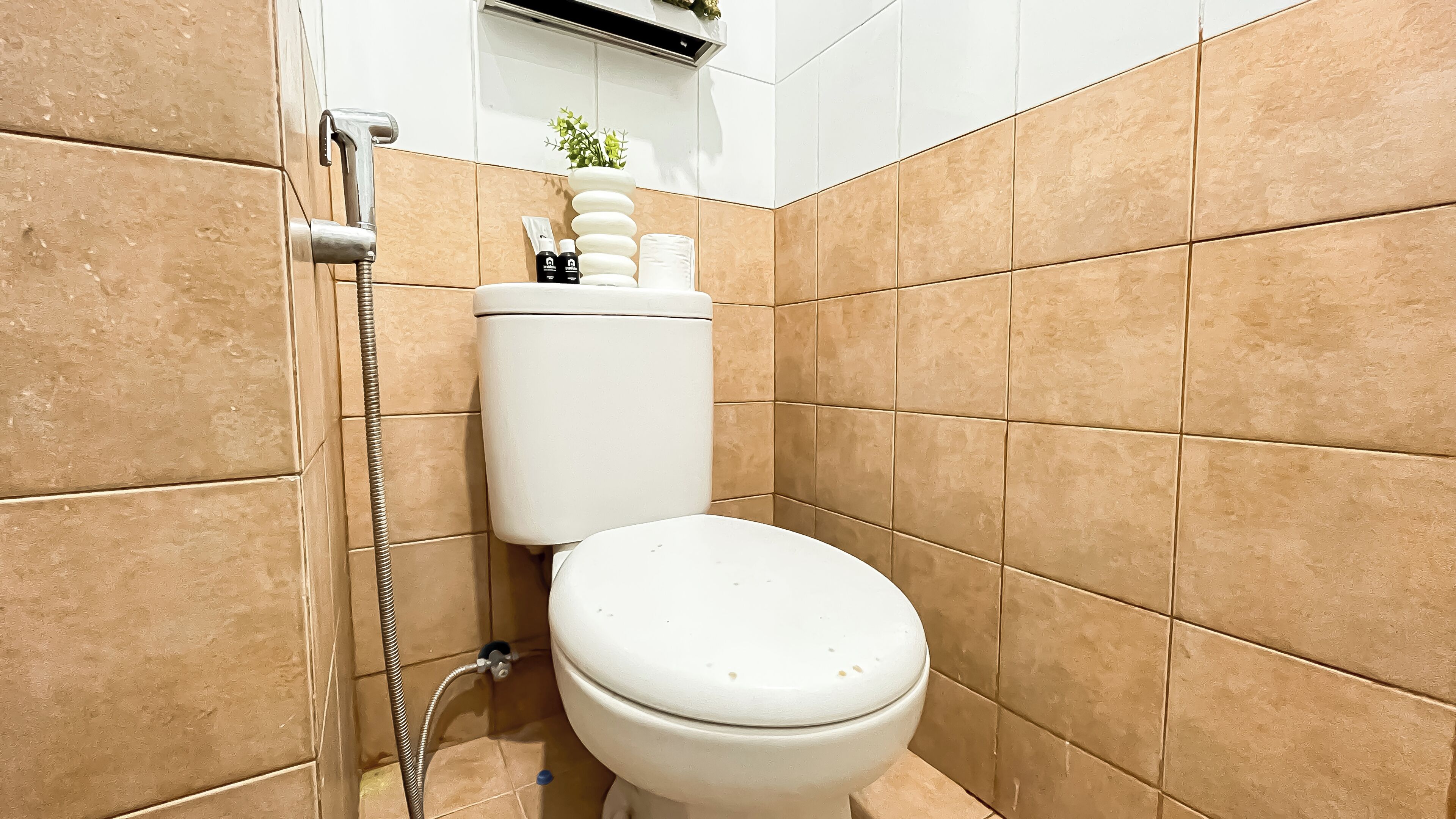 A small bathroom with a toilet, a shower, and a hand dryer.