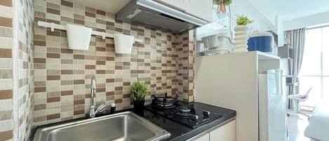 A modern kitchen with a stainless steel sink, a gas stove, and a tiled backsplash.
