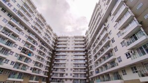 Un edificio residencial de gran altura con múltiples balcones y un patio central.