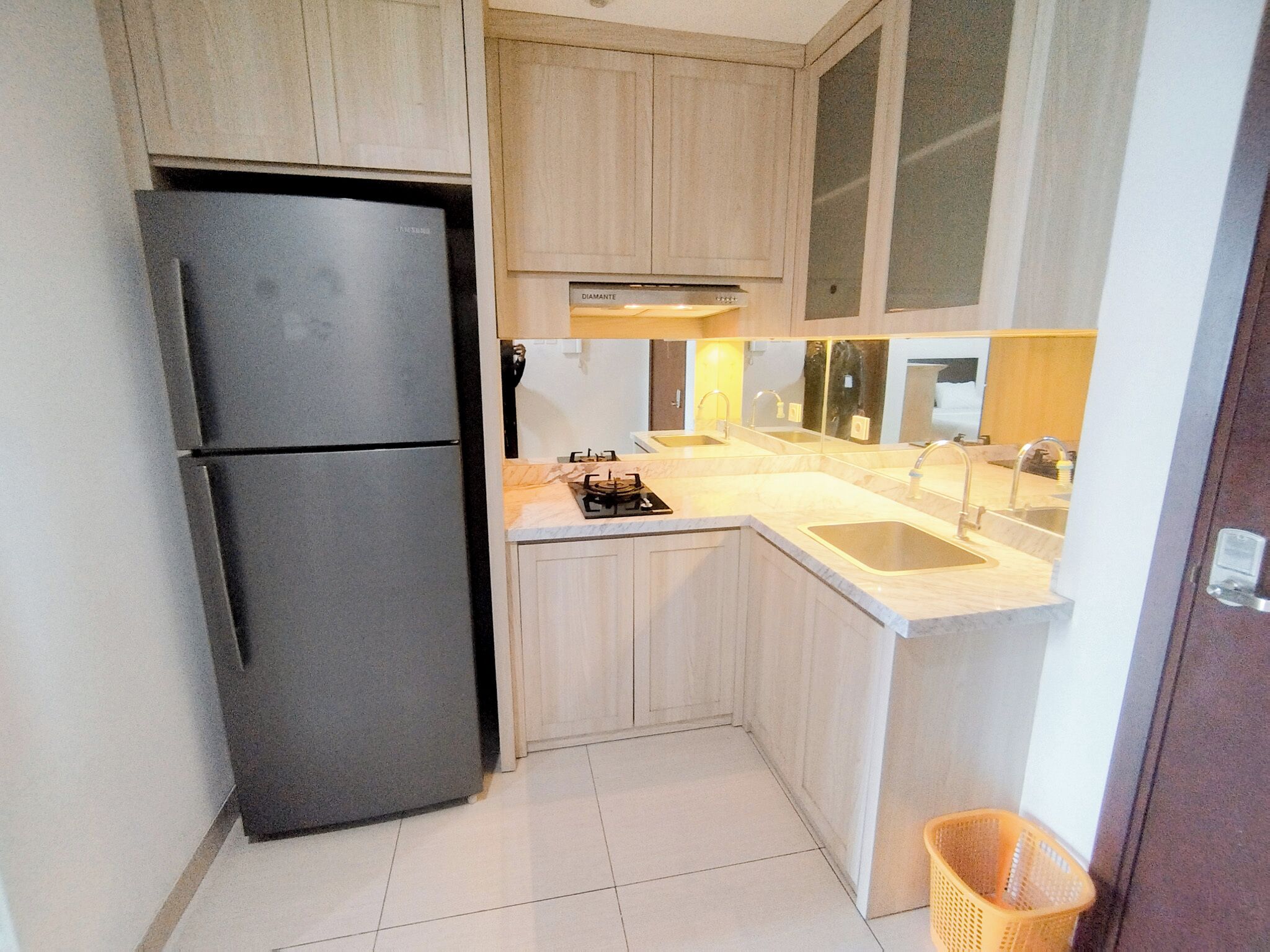 Una cocina compacta con un refrigerador negro, un lavamanos y una estufa.