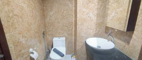A bathroom with a toilet, bidet, and sink.