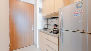Una cocina compacta con refrigerador, estufa y lavamanos.