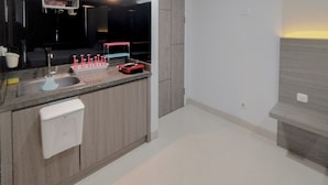 A modern kitchen with a built-in sink, a dish drying rack, and a countertop with a dish soap dispenser. - Simply Design Studio At Taman Melati Surabaya Apartment (Surabaya)