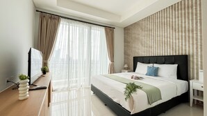 Een moderne slaapkamer met een groot bed, een televisie en een balkon met gordijnen.