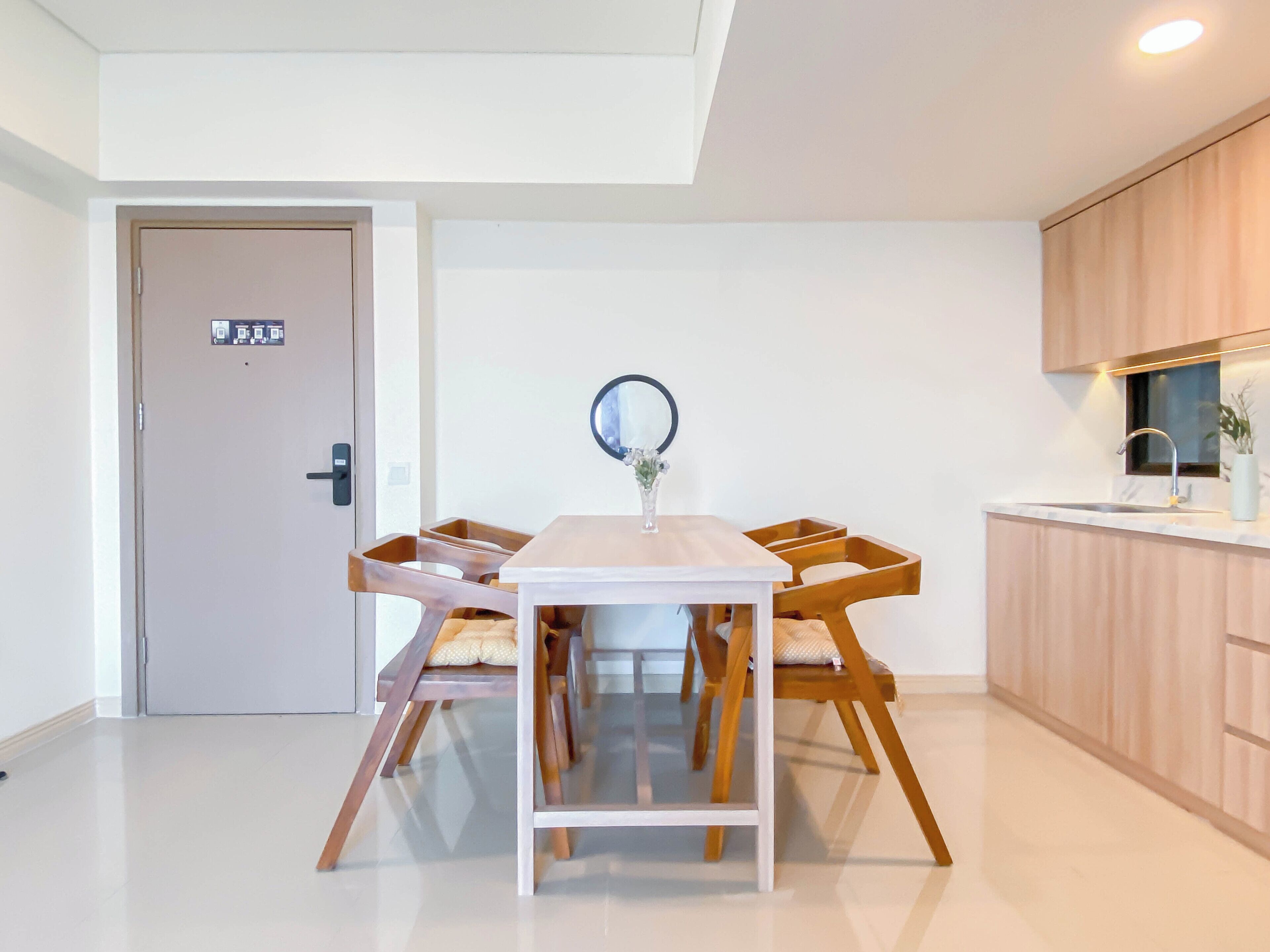 A modern kitchen with wooden cabinets, a white countertop, and a built-in oven.