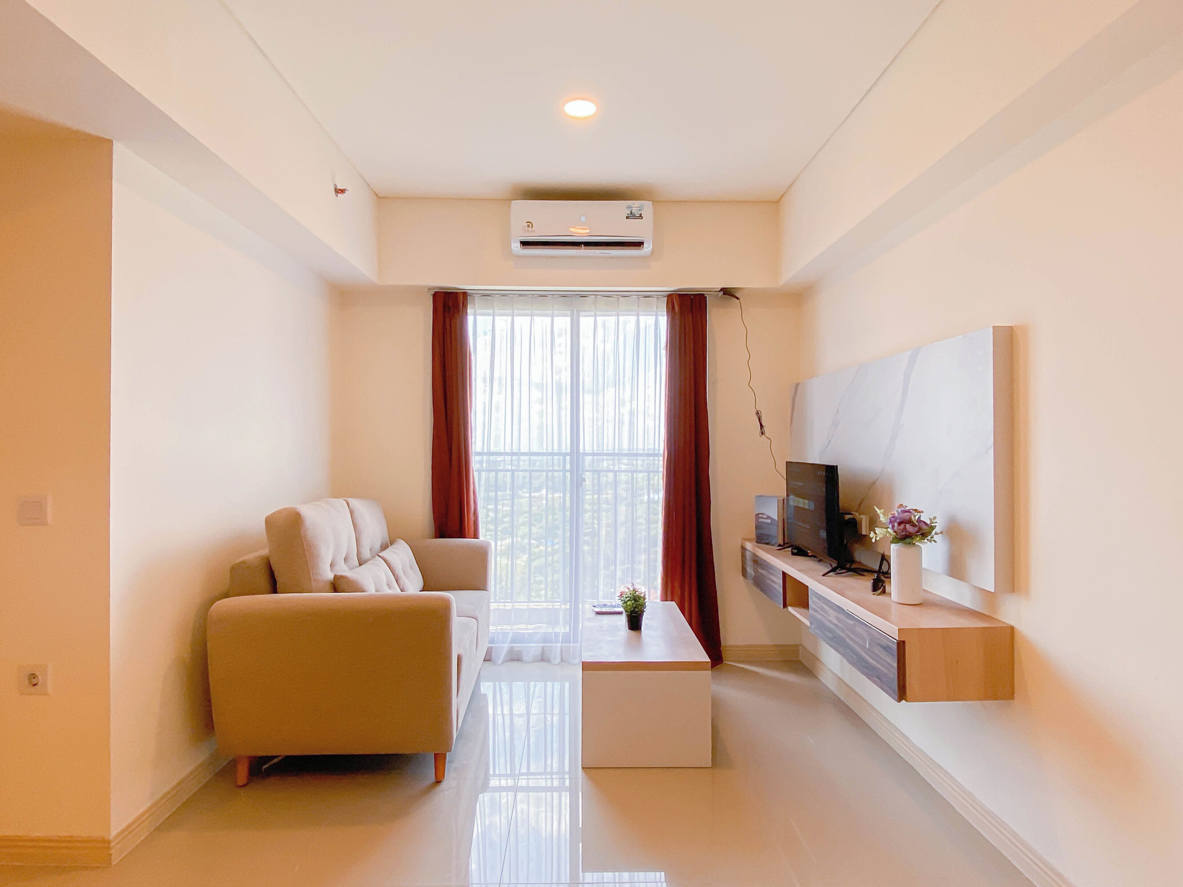 A modern living room with a sofa, a coffee table, a TV, and a mounted artwork.