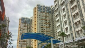 A high-rise residential building with multiple balconies and a blue awning structure in the foreground. - Studio Apartment Near Kebayoran Station At Pakubuwono Terrace (Jakarta)